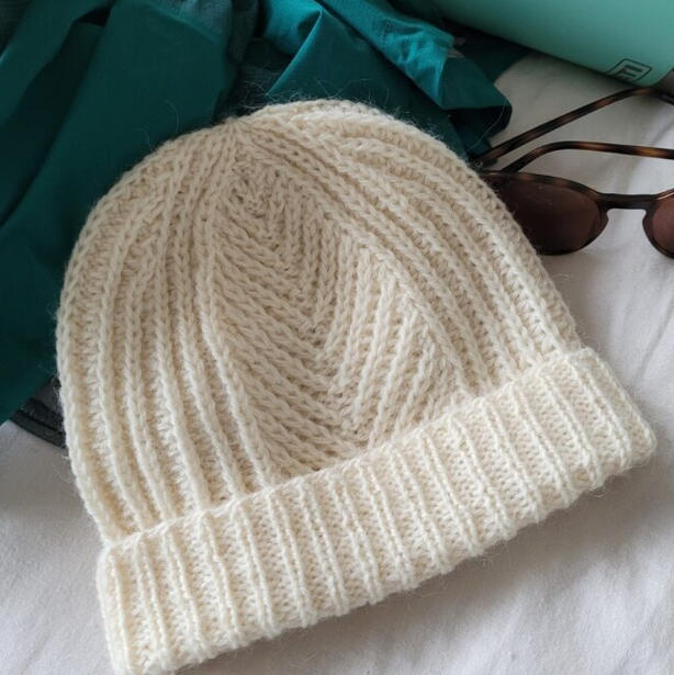 Knitted textured beanie with brioche appearance and fern motif of fishermans rib